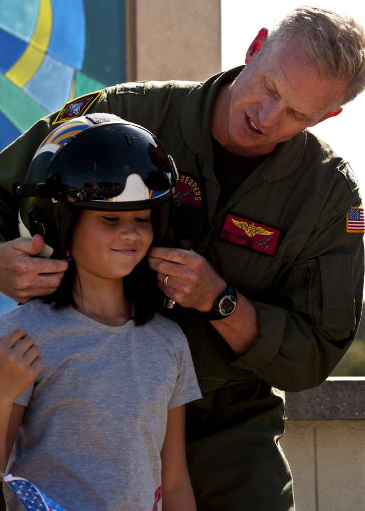 Scott with a young elementary child trying on jet helmet