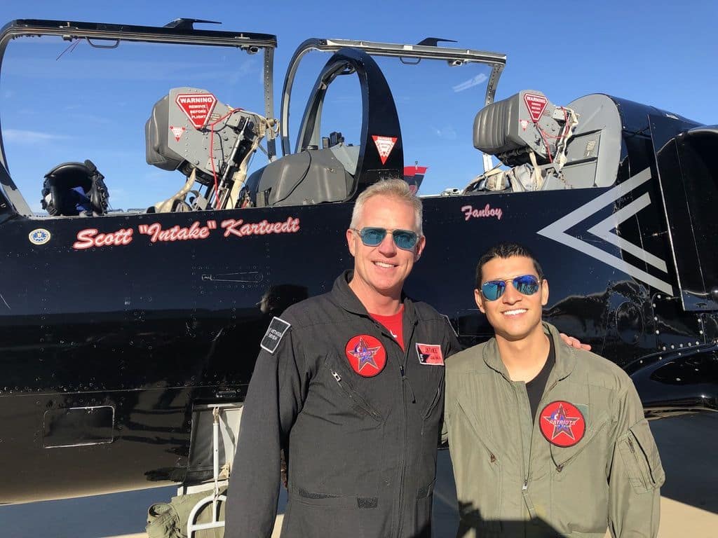 Scott with actor from Top Gun Maverick in front of Patriots team jet