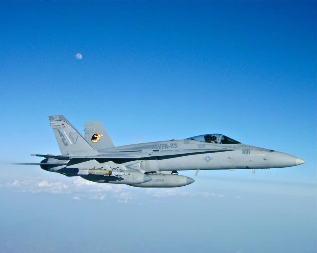 Scott Kartvedt in a fighter jet with the moon behind him