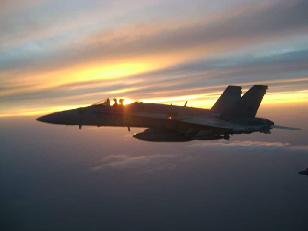 Scott Kartvedt in a fighter jet with a beautiful sunset behind